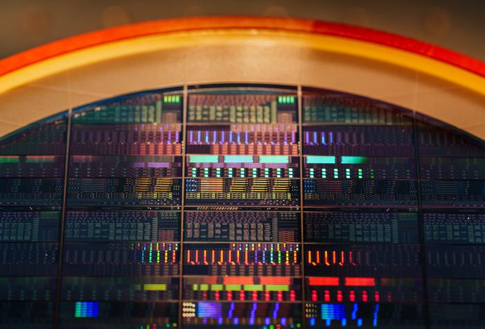 Sandia National Laboratories is collaborating with Arizona State University to advance how light can carry quantum information. Instead of using typical large optical tables, Sandia is developing acousto-optic device technologies, such as the eight-inch wafer above, that can selectively reflect different colors of light. @ Craig Fritz/Sandia National Laboratories