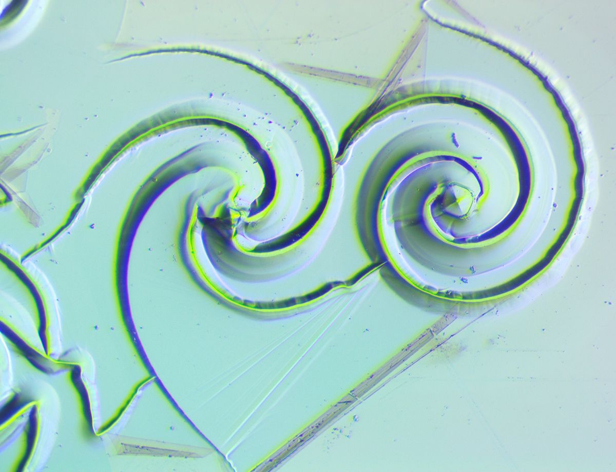 Two logarithmic spirals, each with a diameter of 260 μm, featuring a central etch pit in the shape of an inverted pyramid.