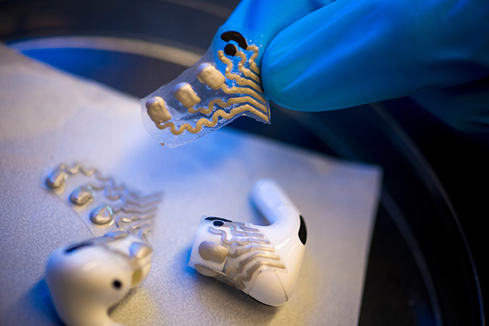 The screen-printed, flexible sensors are attached to the earbuds on a flexible, stamp-like surface. @ University of California, San Diego