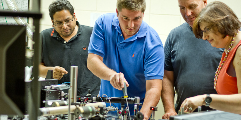 To see more deeply into organic materials, UVM graduate students (from left) Naveen Rawat and Lane Manning, and professors Randy Headrick and Madalina Furis, deployed this table-top scanning laser microscope. Their latest finding is reported in the journal Nature Communications — and may, someday not too far off, let you roll up your computer like a piece of paper. (Photo: Joshua Brown)