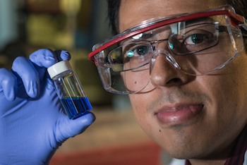 Rice graduate student Victor García-López holds a vial with millions of single-molecule nanosubmersibles. Photo by Jeff Fitlow