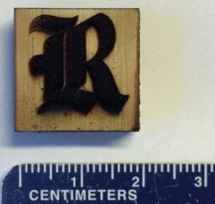 This Rice University athletics logo is made of laser-induced graphene on a block of pine. Rice scientists used an industrial laser to heat the wood and turned its surface into highly conductive graphene. The material could be used for biodegradable electronics. @ Tour Group/Rice University