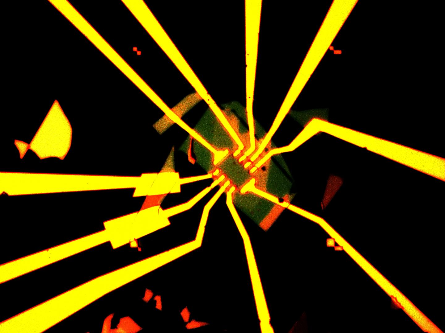An enhanced optical microscope image of a Hall-bar structure used to characterize transistor properties for devices made with ultraclean transferred contacts. The long radial lines, made from deposited gold, connect the small contacts at the center of the device to large probe pads for easy measurements. @ Min Sup Choi/Columbia Engineering